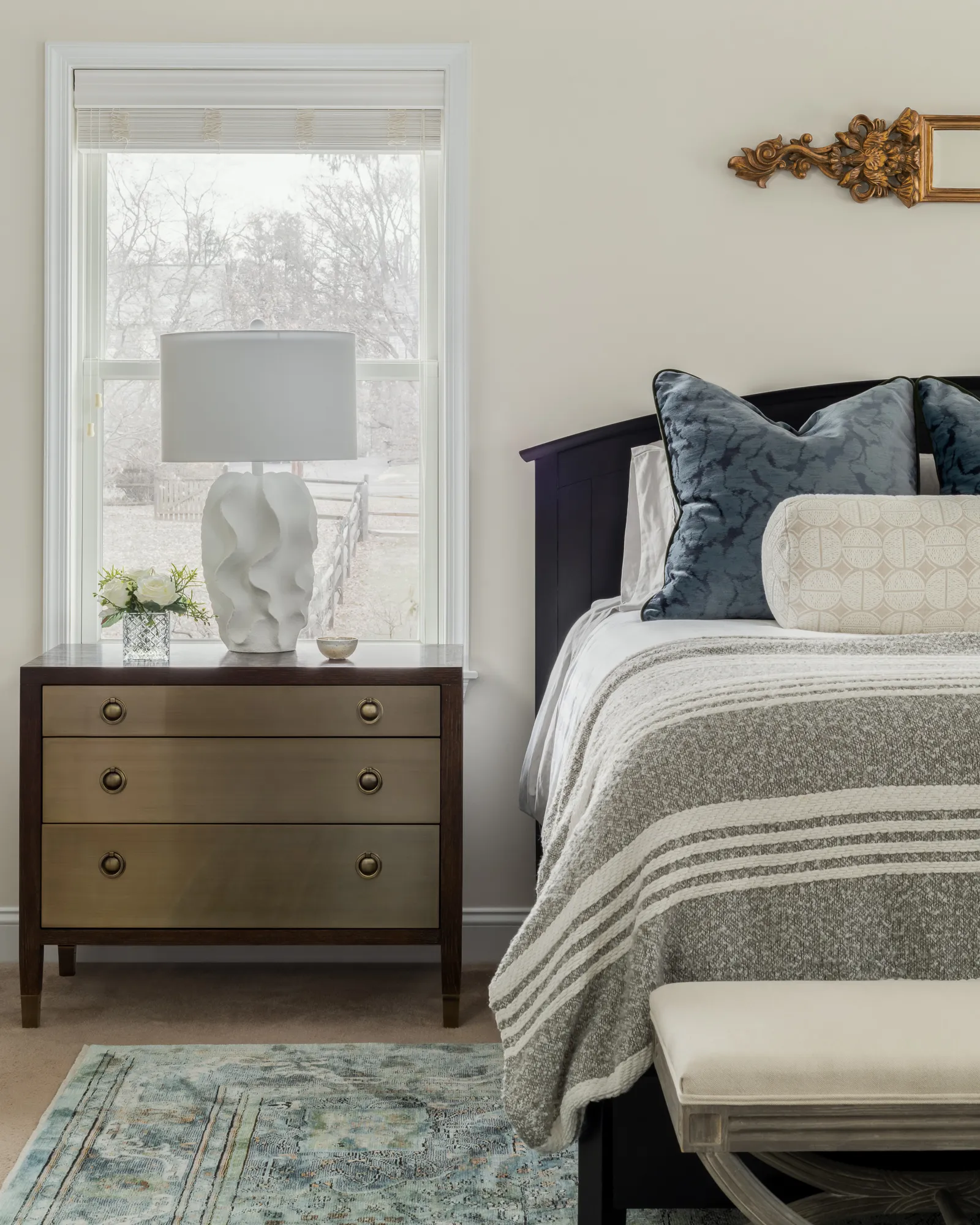 Nightstand vignette with floral arrangement and brass lamp
