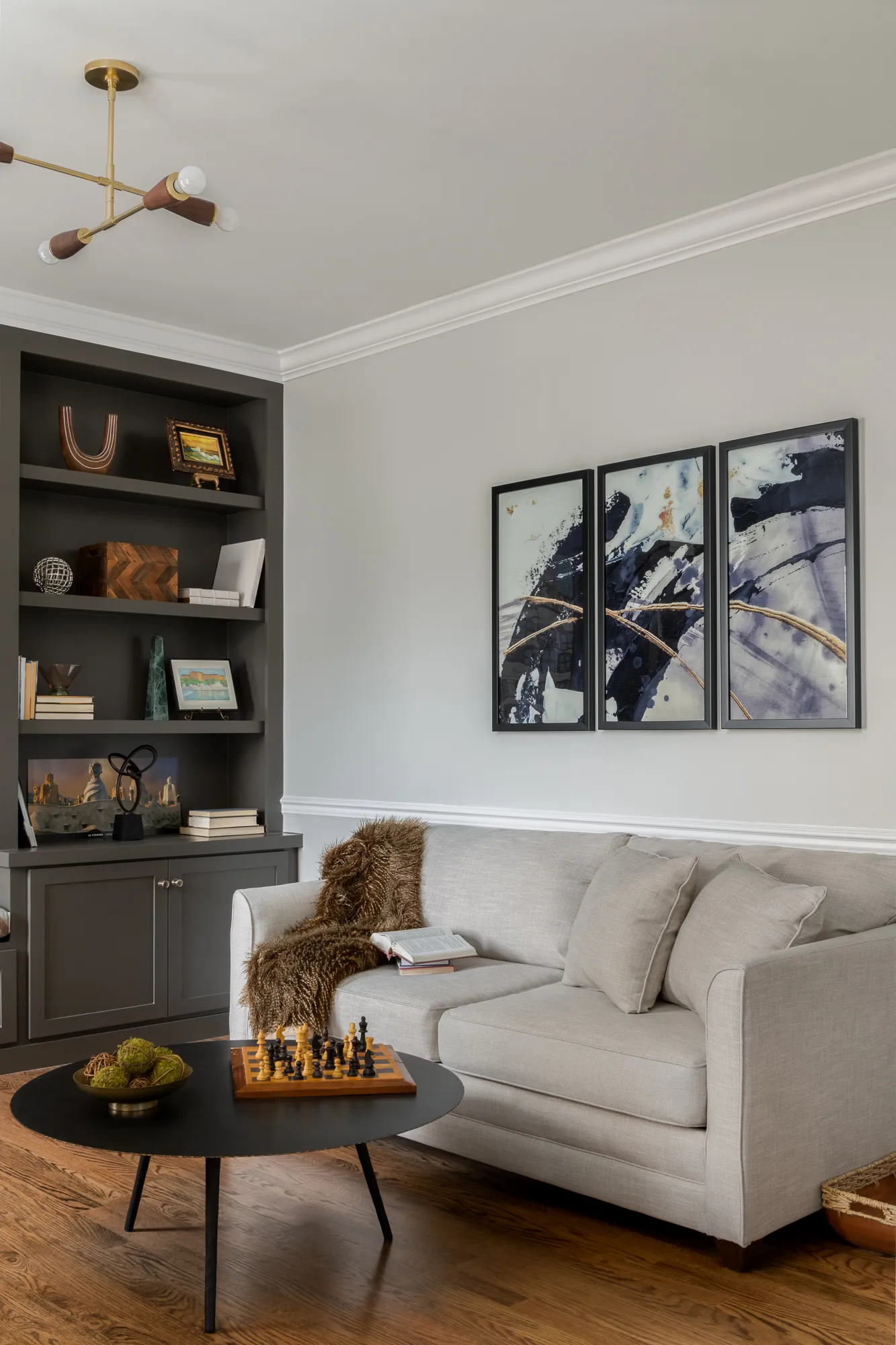 Cream linen sofa beneath triptych artwork