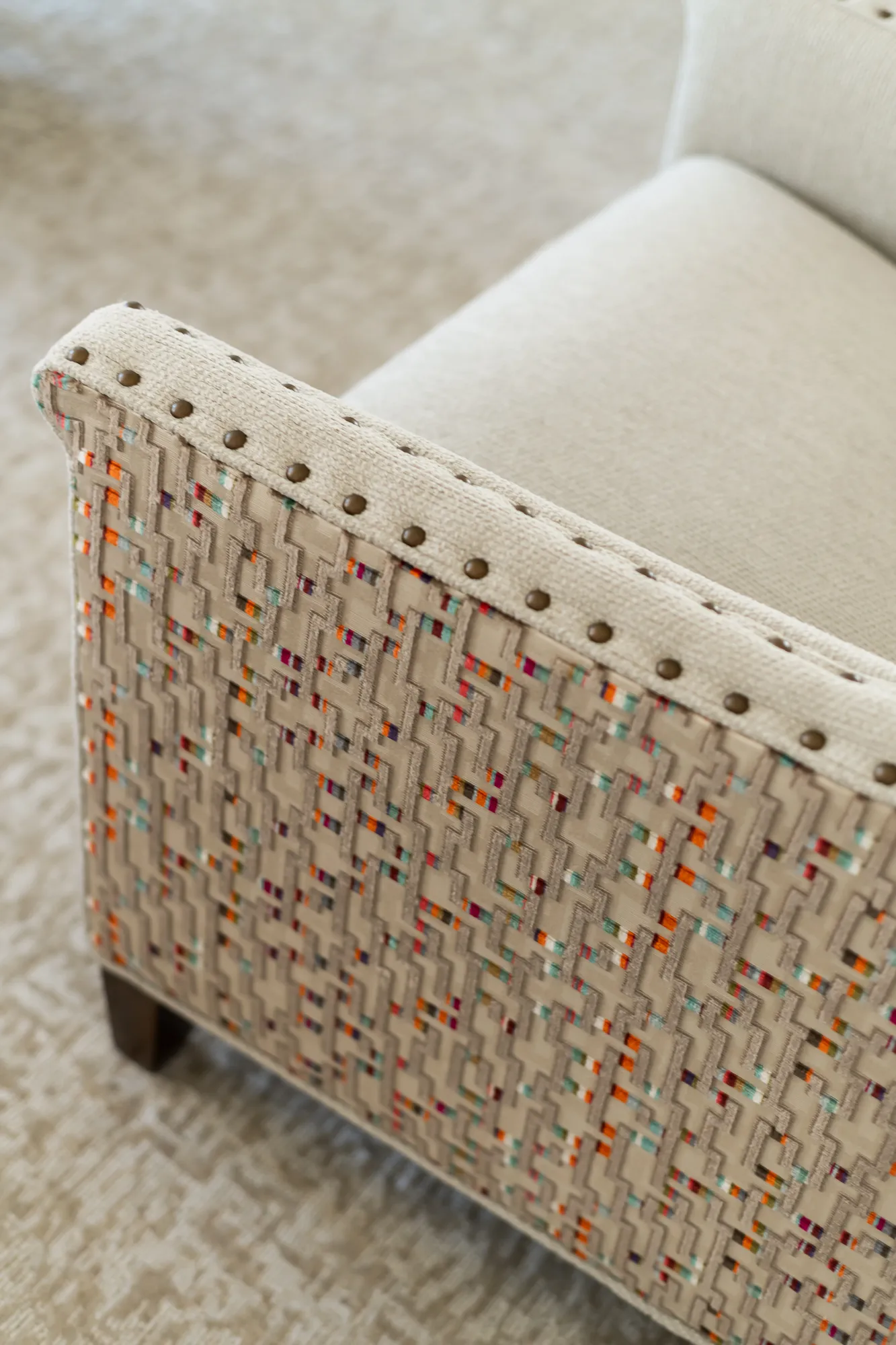 Multicolored woven chair fabric with nailhead trim detail