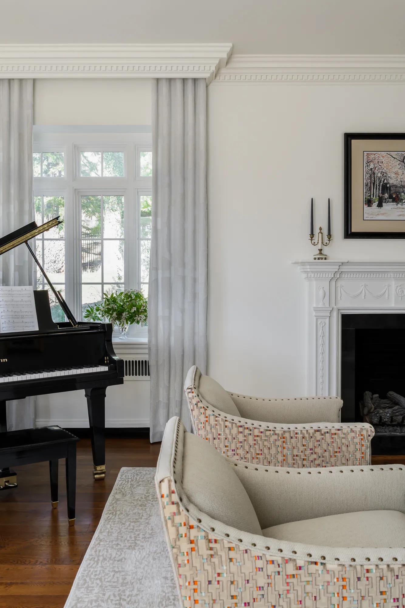 Grand piano corner with carved fireplace mantle and woven accent chairs