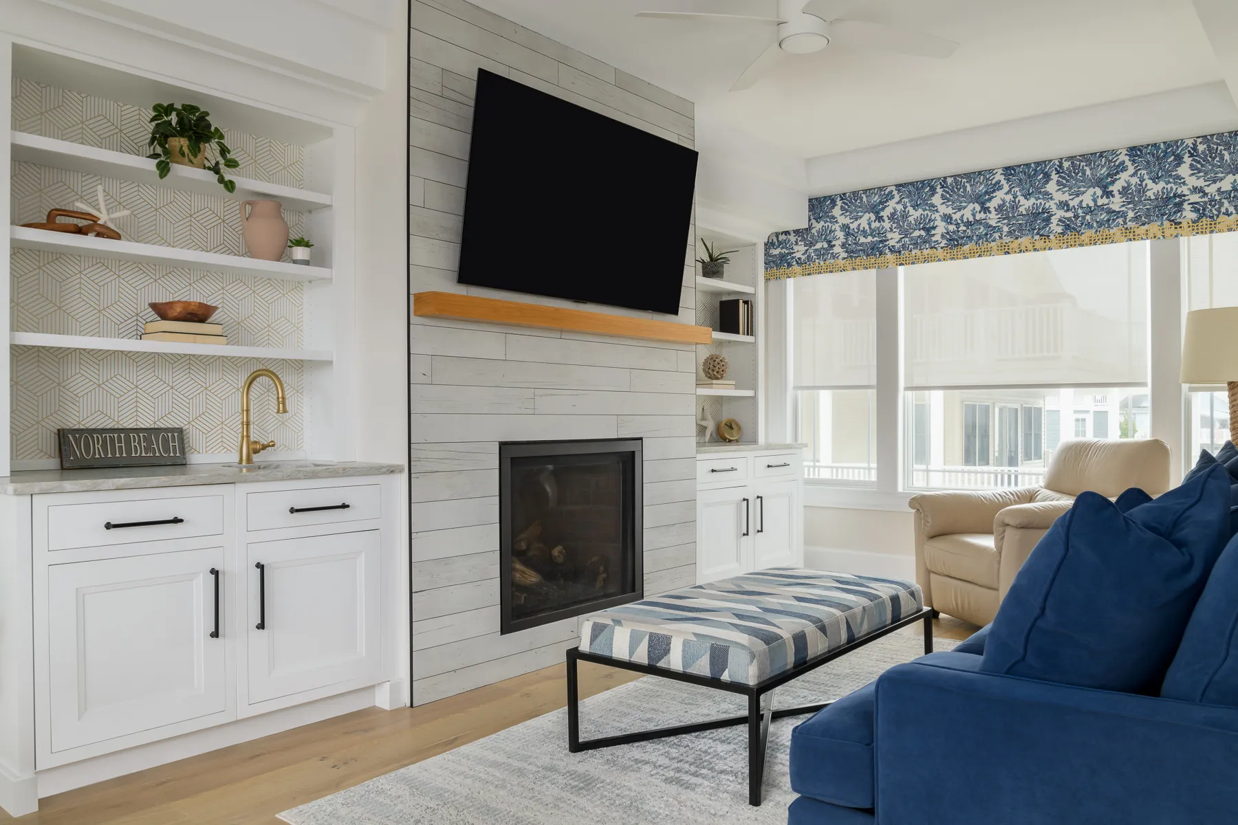 Living room with shiplap fireplace, built-in wet bar, and navy sofa
