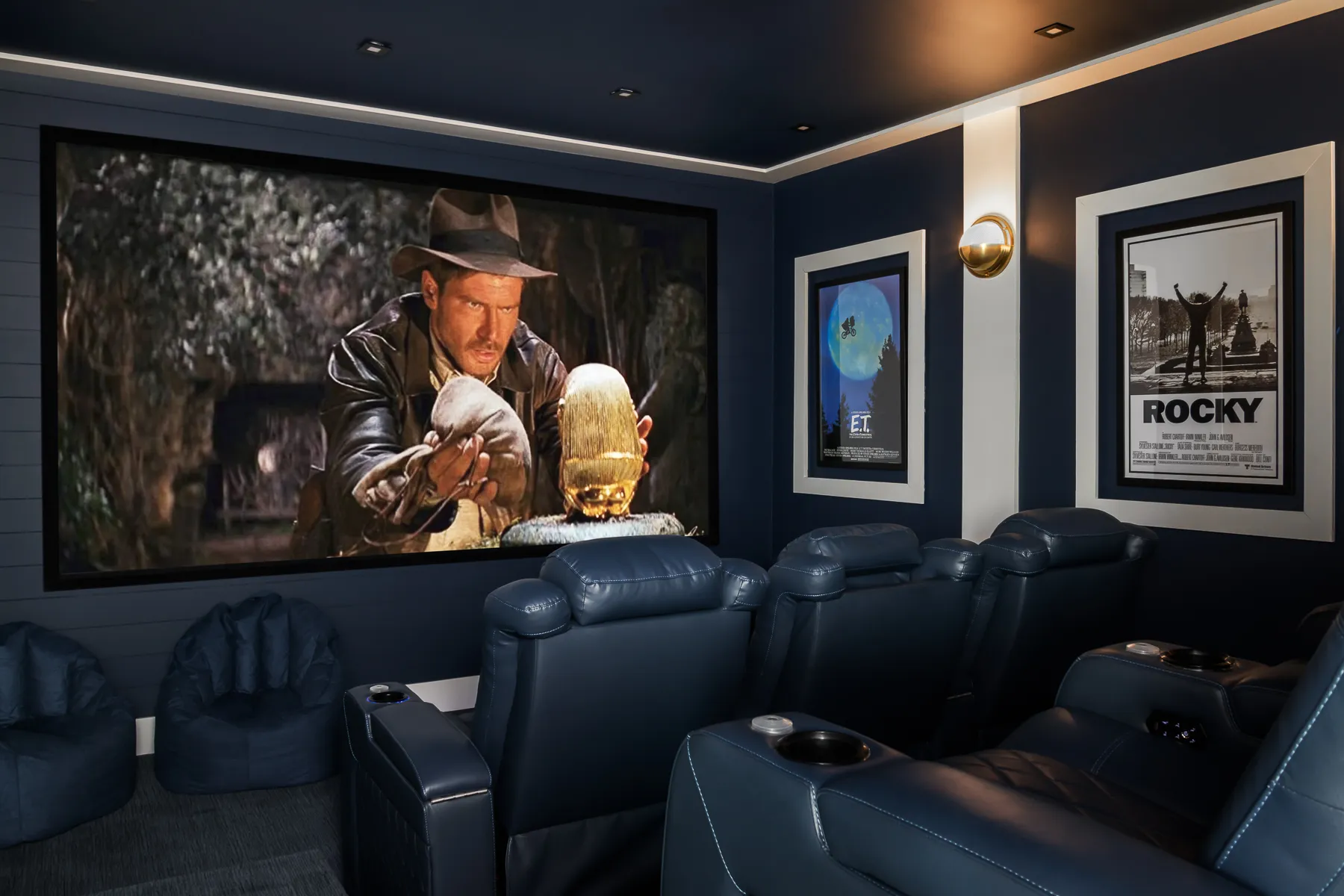 Home theater in navy shiplap with leather recliners and framed movie posters