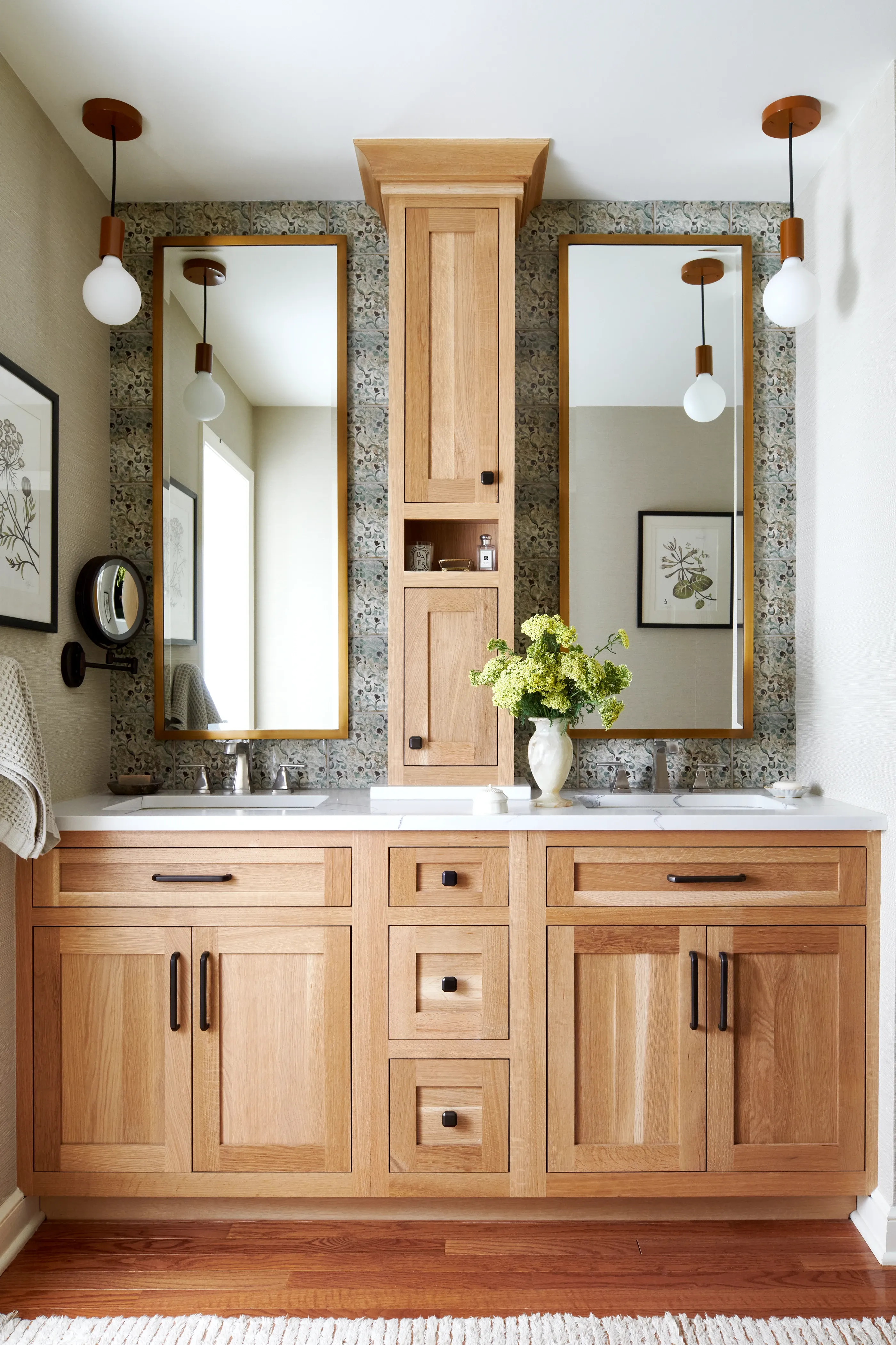 White oak double vanity with quartz top, floral mosaic backsplash, and walnut pendant lights