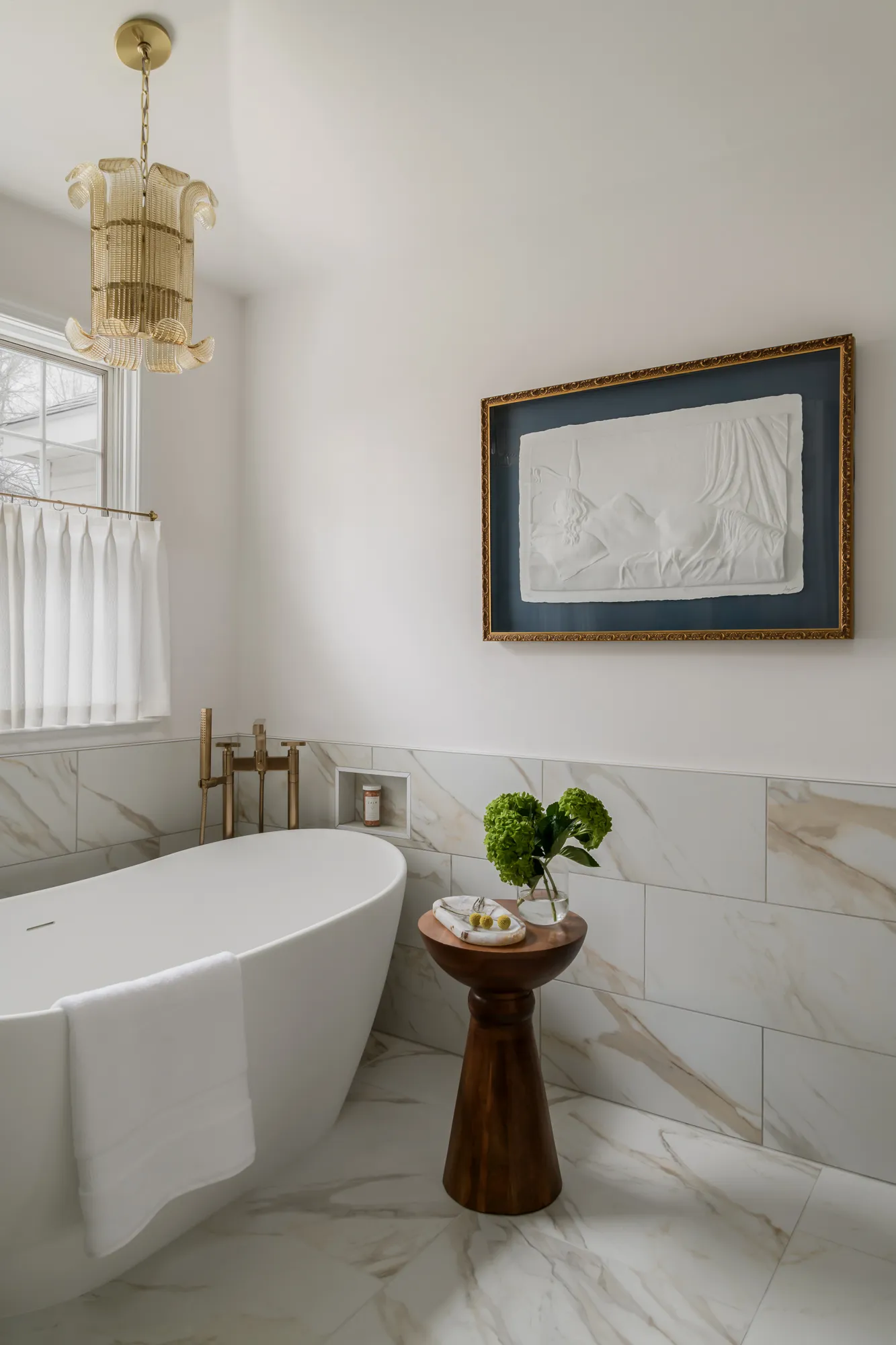 Tub corner with white plaster relief artwork in gold frame