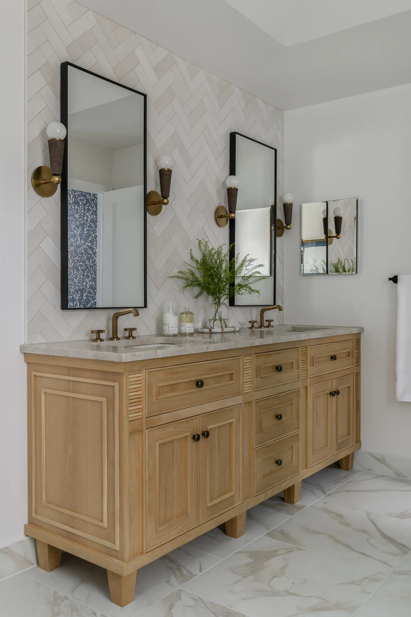 Double vanity with natural oak louvered cabinetry and marble top